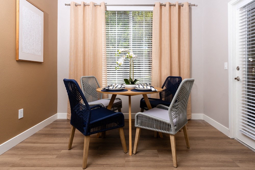 a dining room with a table and chairs and a window