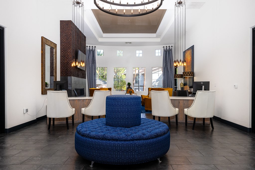 a living room with a blue chair and a table with chairs