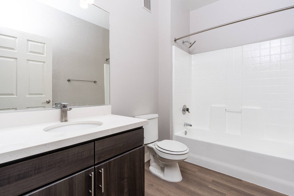 a bathroom with a toilet sink and shower and a mirror