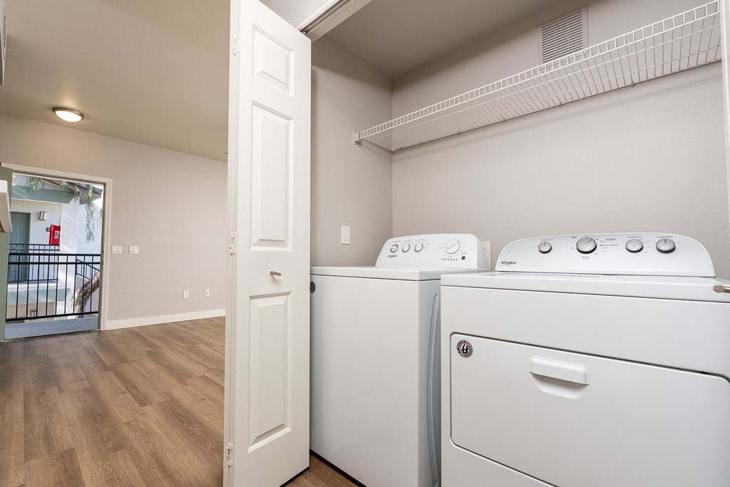Apartments for Rent in 89147, Spring Valley, NV - Alicante - Bathroom with Hardwood-Style Floor, Bathtub, Wood-Tone Cabinet, Mirror, and Laundry Closet with Washer and Dryer