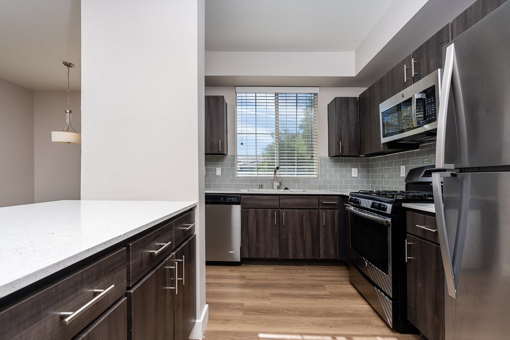 an updated kitchen with stainless steel appliances and wooden cabinets
