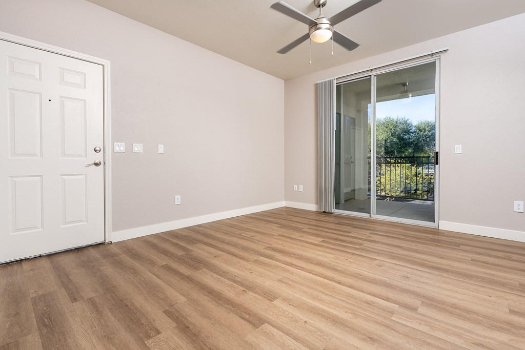 a living room with wood flooring and a ceiling fan