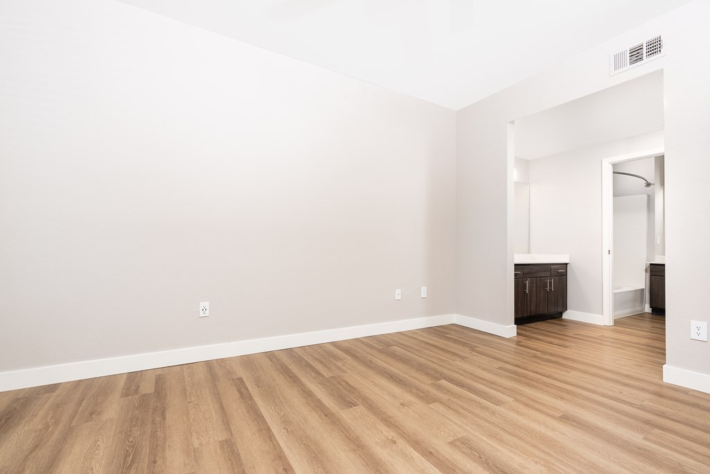 an empty living room with white walls and wood flooring