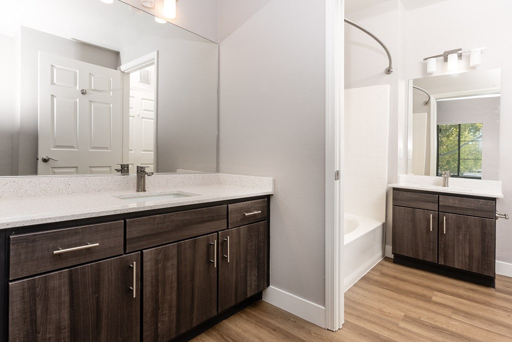 a bathroom with wooden cabinets and a sink and a mirror