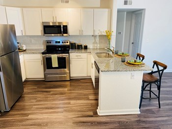Apartments for Rent Denver CO - Allure Apartments Kitchen With Stainless Steel Appliances, Hardwood Floors, Granite Countertops, And Sleek White Cabinetry - Photo Gallery 12