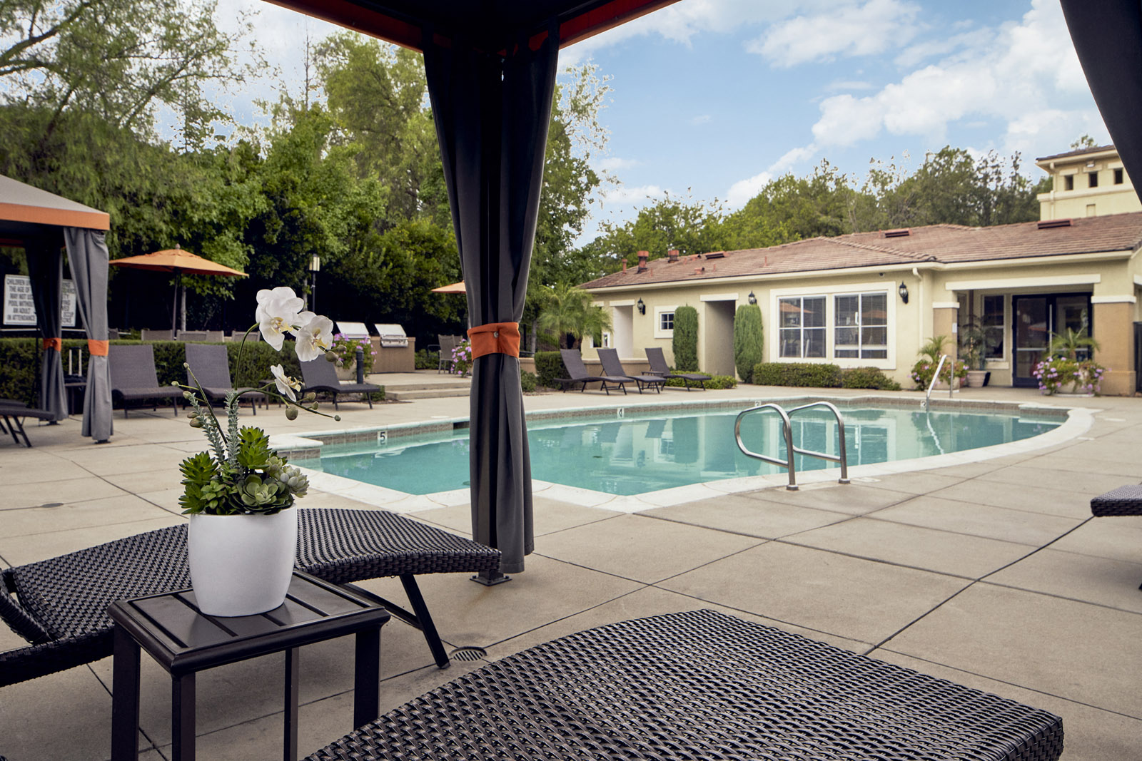 Outdoor pool area with cabanas
