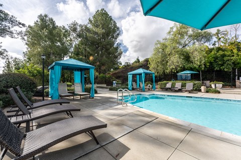 a swimming pool with chairs and umbrellas at Alta Vista, Escondido