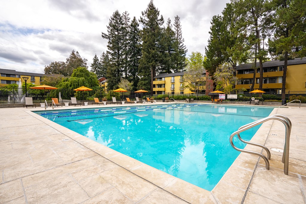 Outdoor pool area with lounge chairs at Americana Apartments, California, 94040
