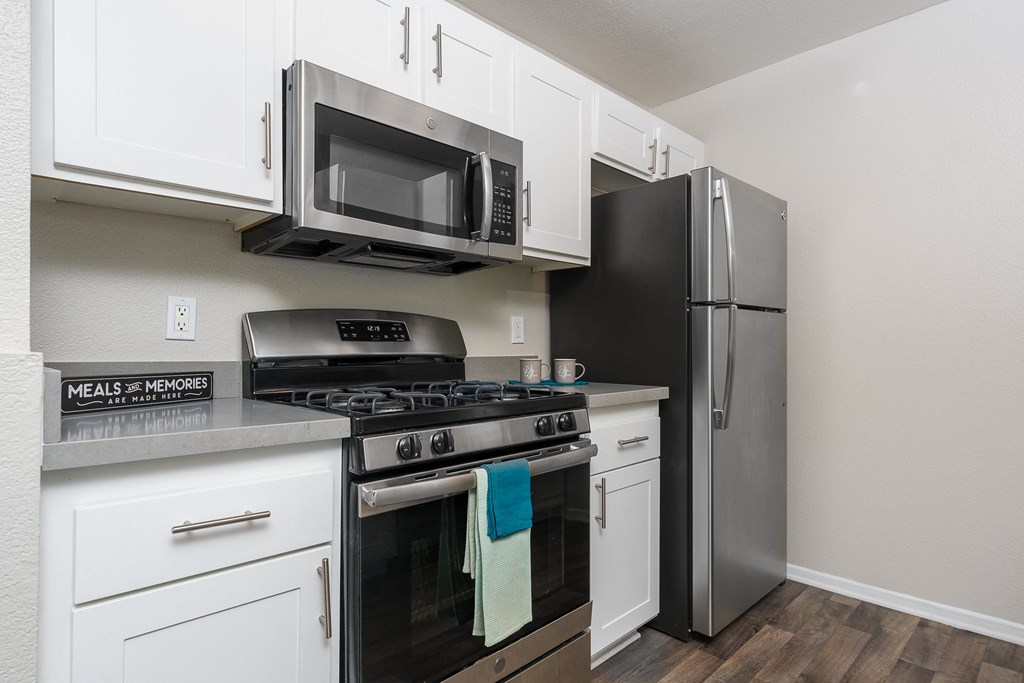 a kitchen with white cabinets and stainless steel appliances at 55+ FountainGlen Temecula, Temecula