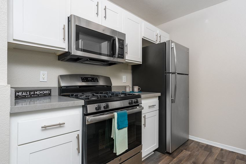a kitchen with white cabinets and stainless steel appliances - Photo Gallery