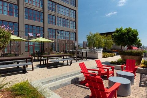 Apartments for Rent in Oakland - Aqua Via - Courtyard with Chairs, Umbrellas, BBQ Area, Grills, and Picnic Tables at Aqua Via Apartments, Oakland, California