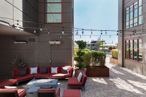 a patio with couches and a firepit in front of a building at Aqua Via Apartments, Oakland, 94607