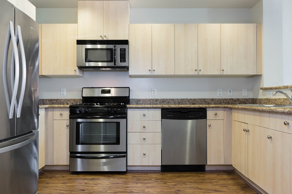 Oakland CA Apartments - Aqua Via - White Kitchen with Granite Countertops, Stainless Steel Appliances & Wood-Style Flooring