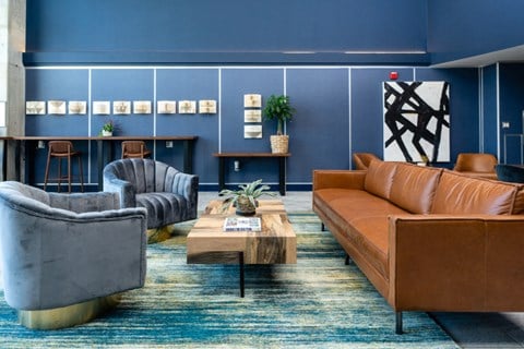 a living room with blue walls and leather couches and chairs