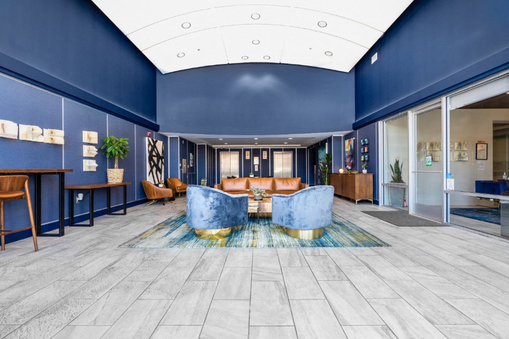 furnished lobby with high ceiling and blue wall