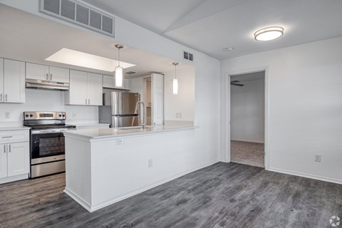 A modern kitchen with white cabinets and stainless steel appliances.