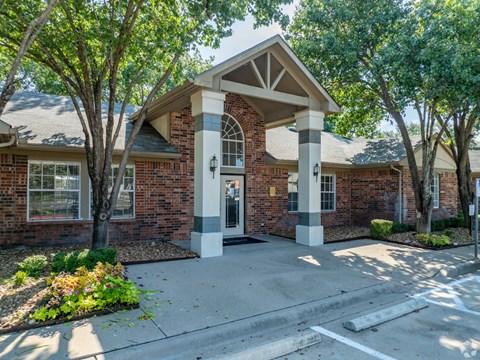 A brick building with a white door and pillars.