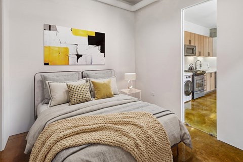 A bedroom with a large bed and a painting on the wall.