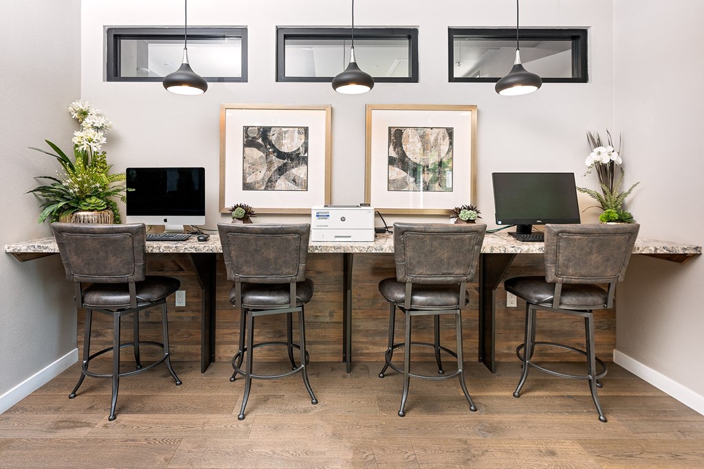 an office with a long desk with two computers on top of it