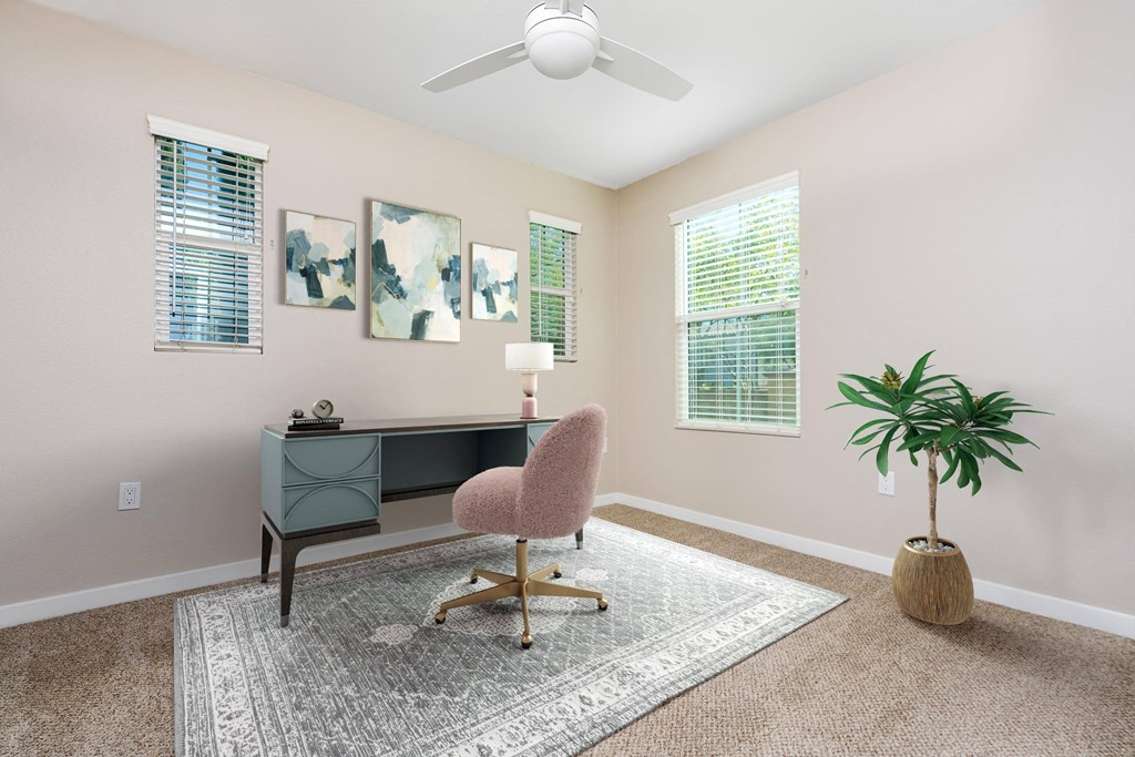 a desk with a chair and a plant in a room with beige walls and a ceiling