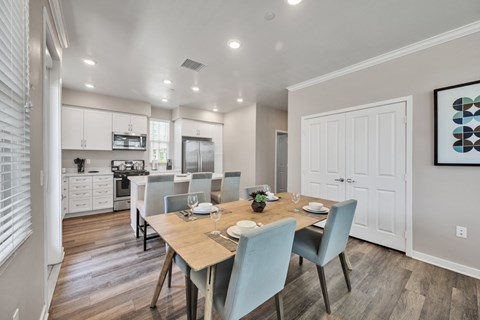 A dining room with a table set for four.