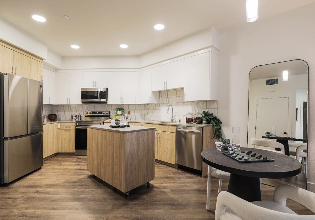 Pet-Friendly Apartments in Brooklyn Basin Oakland, CA - Artizan - Modern Style Kitchen with Plank-Style Flooring, Wood Grain Cabinetry, Stainless Steel Appliances, and Spacious Countertop