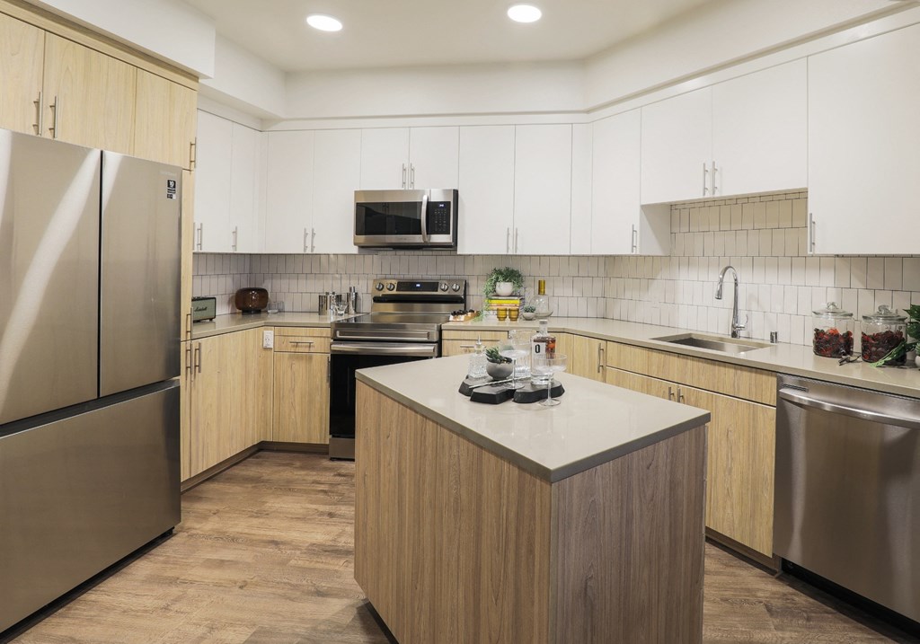 Pet-Friendly Apartments in Brooklyn Basin Oakland, CA - Artizan - Modern Style Kitchen with Plank-Style Flooring, Wood Grain Cabinetry, Stainless Steel Appliances, and Spacious Countertop