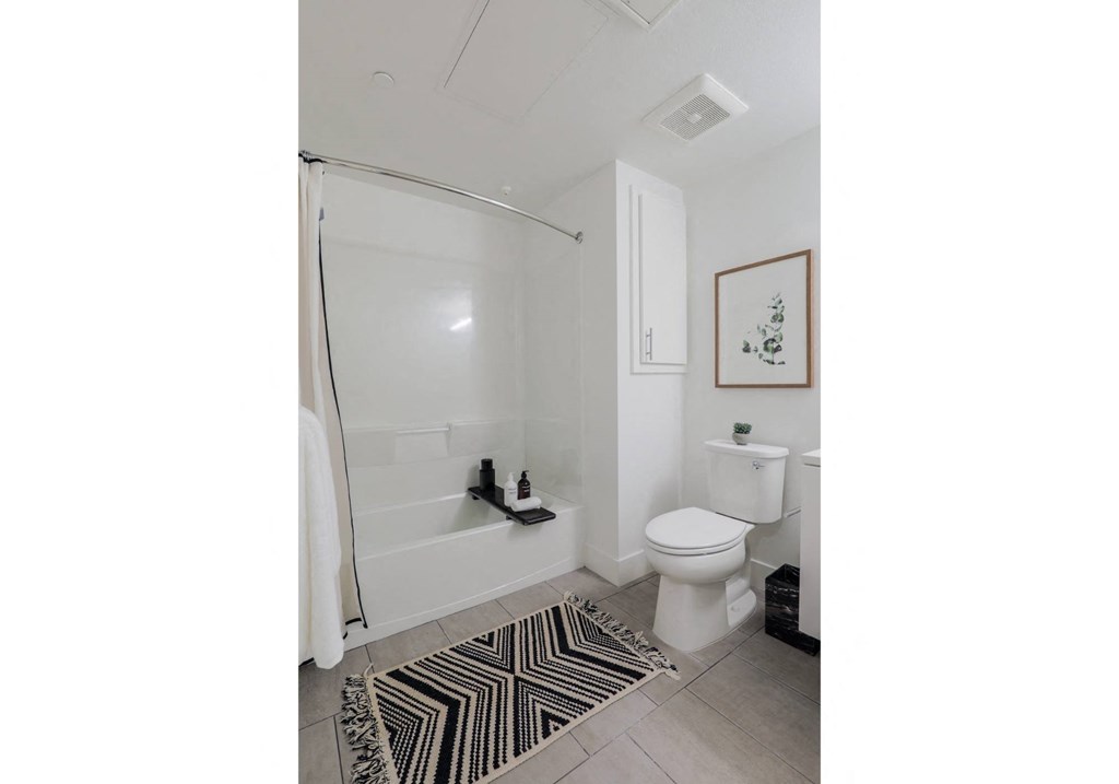 Apartments for Rent in Brooklyn Basin Oakland, CA - Artizan - Spacious Bathroom with White Cabinetry, Vanity Mirror, and Toilet