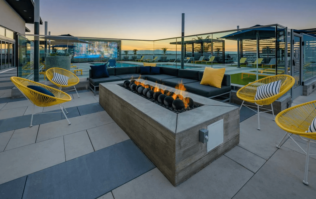 a rooftop patio with a fire pit and chairs and tables
