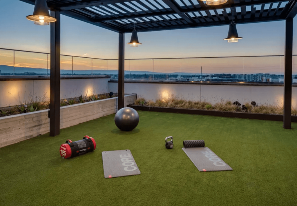 a roof gym with a view of the water at sunset