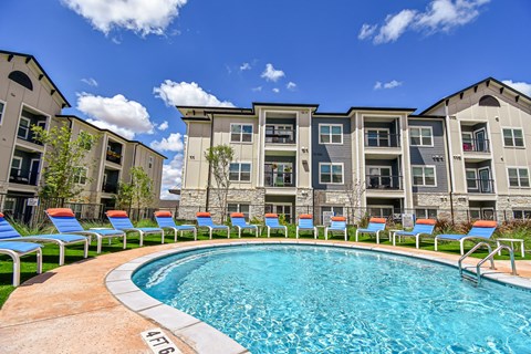 A swimming pool in front of apartment buildings.