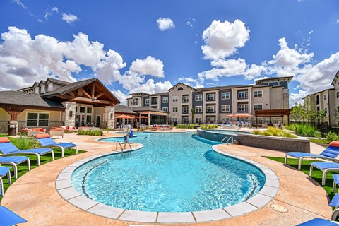 A large outdoor swimming pool surrounded by lounge chairs.