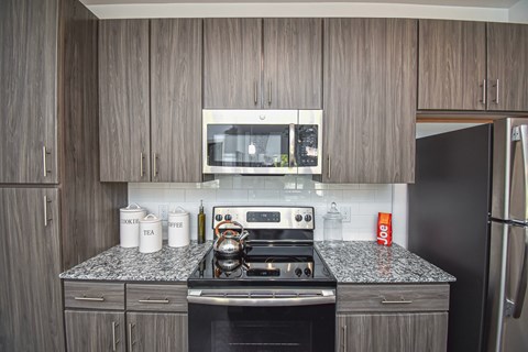 A kitchen with a black stove top oven and a microwave above it.
