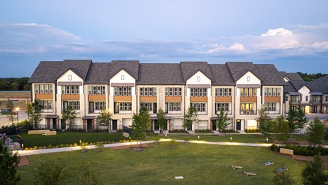 A large, modern building with a grassy lawn in front.