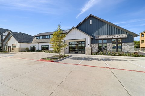 A large building with a grey roof and a black garage door.