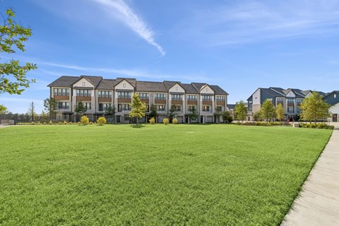 A large building with a green lawn in front of it.