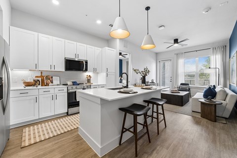 A modern kitchen with white cabinets and a large island.