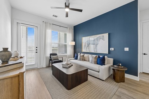 A living room with a white couch and a ceiling fan.