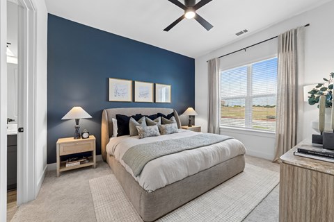 A bedroom with a large bed and a ceiling fan.