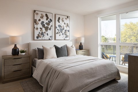 A bedroom with a large bed and two lamps on either side.