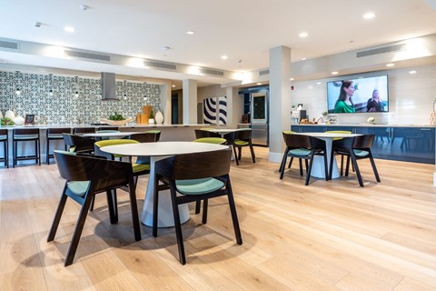 A modern dining room with a large table surrounded by chairs.