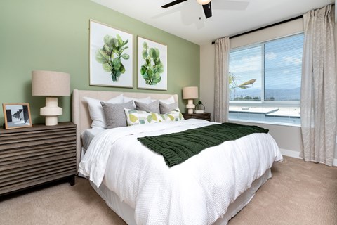 A bedroom with a large bed and two framed pictures on the wall.