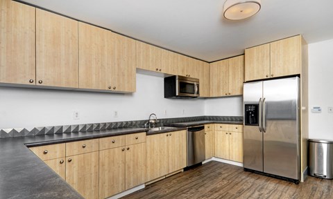 a kitchen with wooden cabinets and a stainless steel refrigerator