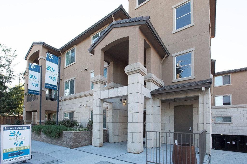 North San Jose CA Apartments - Aviara - Property Exterior with Tan Walls, White Brick Details, and Landscaped Plant Beds