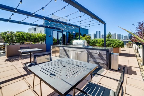 a patio with a table and a bar and a city in the background