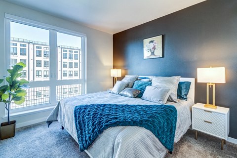 a bedroom with a bed and a large window