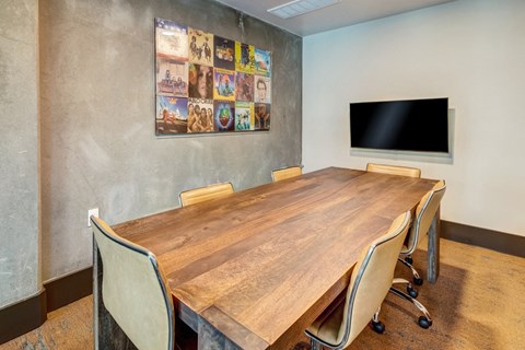 a conference room with a large wooden table and a television