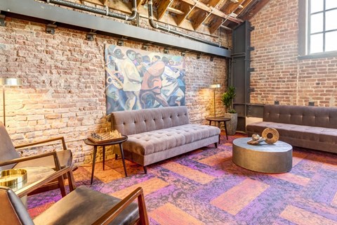 a living room with couches and a painting on the wall