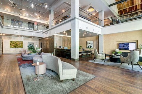 a lobby with couches and chairs and a tv