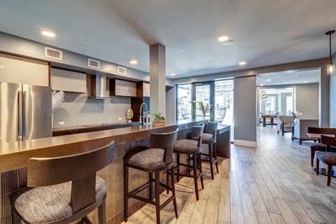 a large kitchen with a bar and chairs in a hotel room
